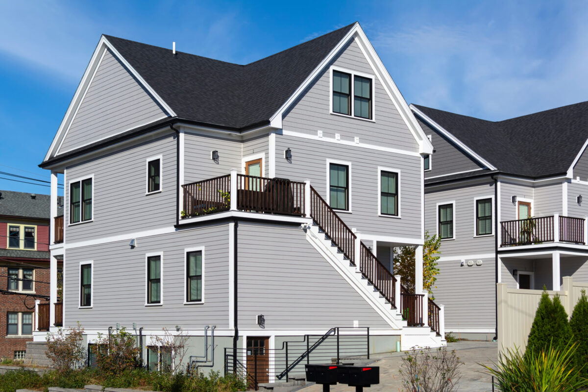 Newly built two-story family home with cross-gable roof in lap siding