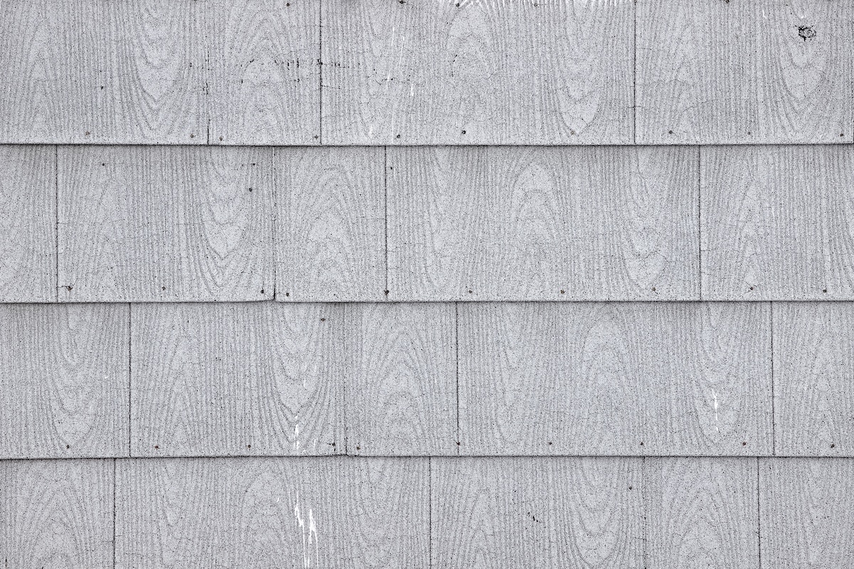 Old asbestos shingle siding on a house background
